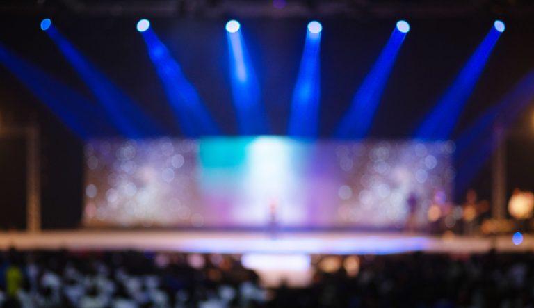 Concert stage blurry background lights spotlight energetic atmosphere audience celebration dynamic performance festival excitement applause festivity music illumination venue special occasion fun